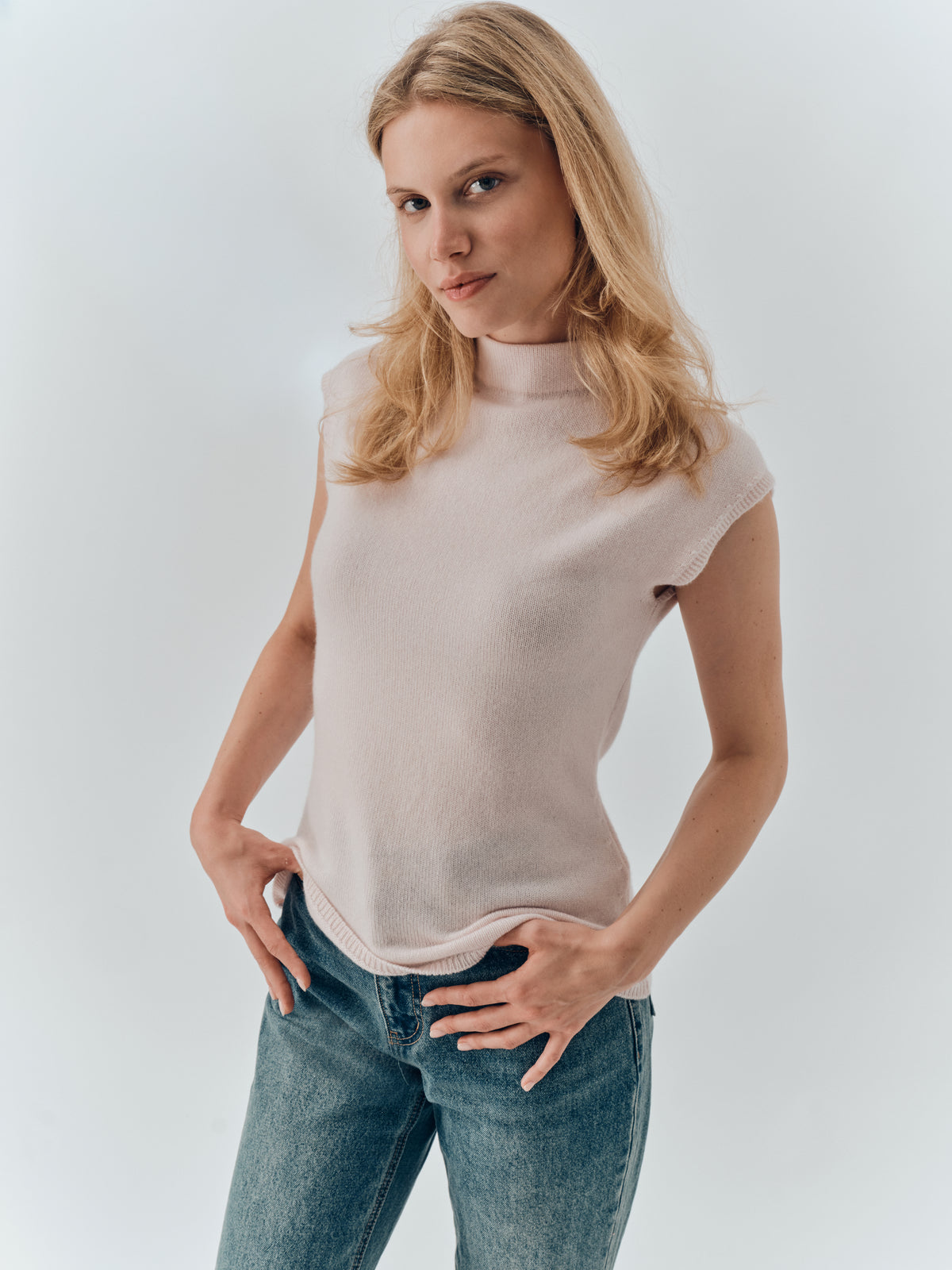 Thalia Top in Blush cashmere, worn with jeans, showing the cap sleeve and mock neck
