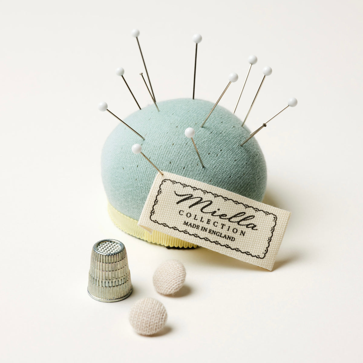Close-up of a Miella label and pin cushion