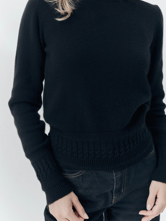 Betsy Jumper in Black cashmere, worn with black denim, showing the textured hem and cuffs