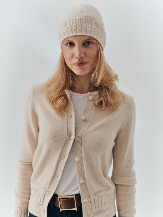 Cable-knit cashmere beanie in Champagne worn with matching cashmere wrist warmers