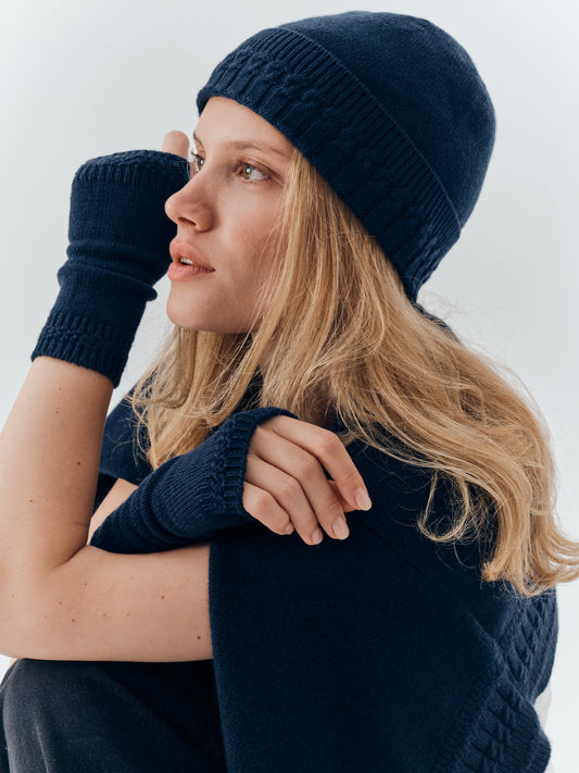 Cable-knit cashmere beanie in Navy worn with matching cashmere wrist warmers