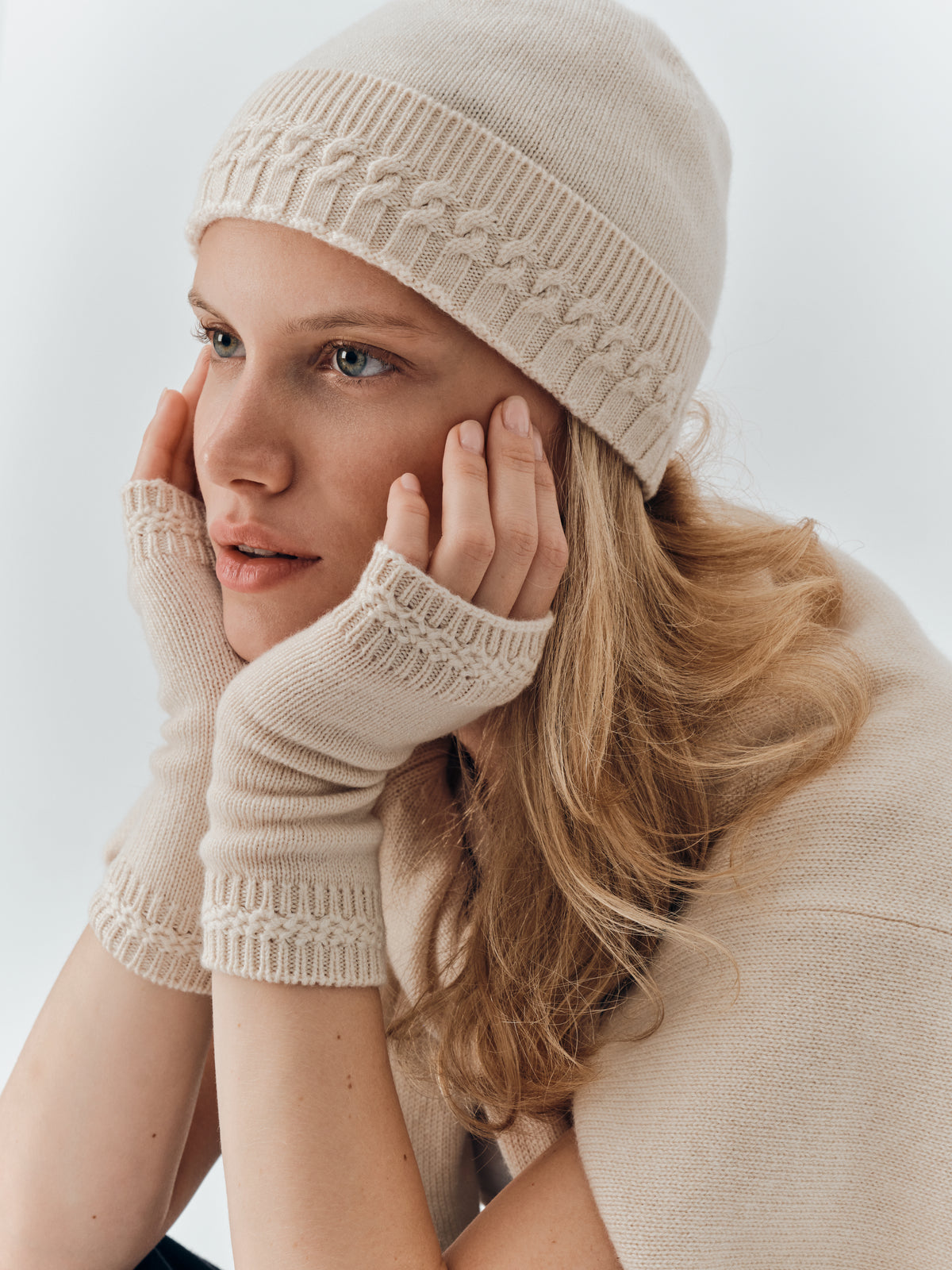 Cashmere wrist warmers in Champagne worn with the Cable Knit Beanie in Champagne